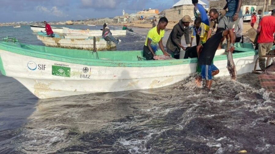 Fishermen prepare a boat for use after repairs.